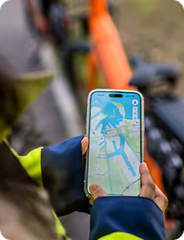 Person holding smartphone showing digital map with an outdoor background.